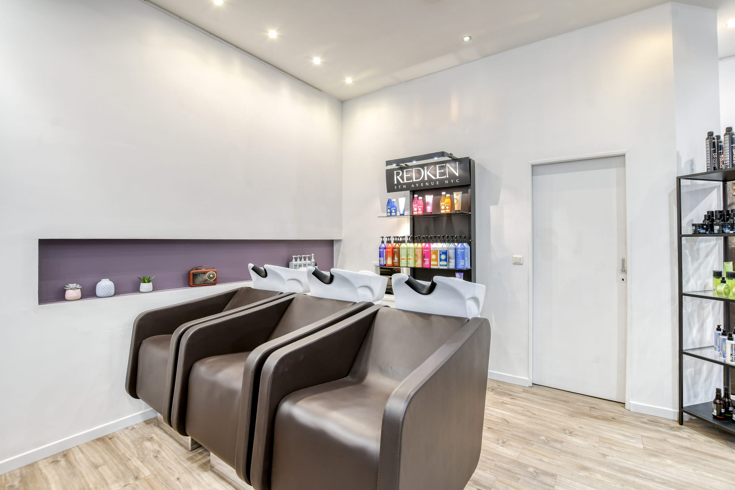 Bacs à shampoing et présentoir Redken au salon Addict Coiffure
