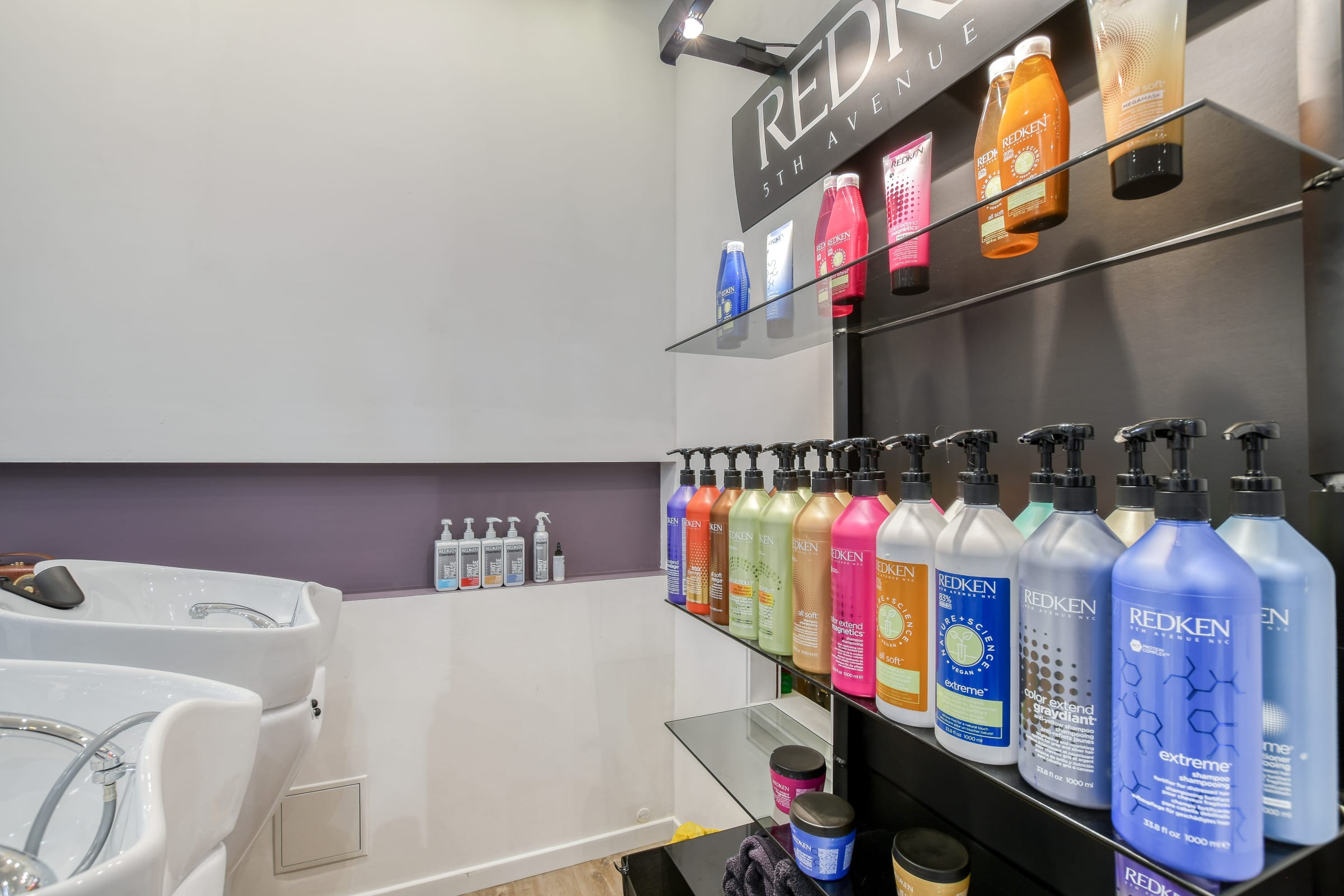 Présentoir de produits Redken près de l’espace shampoing